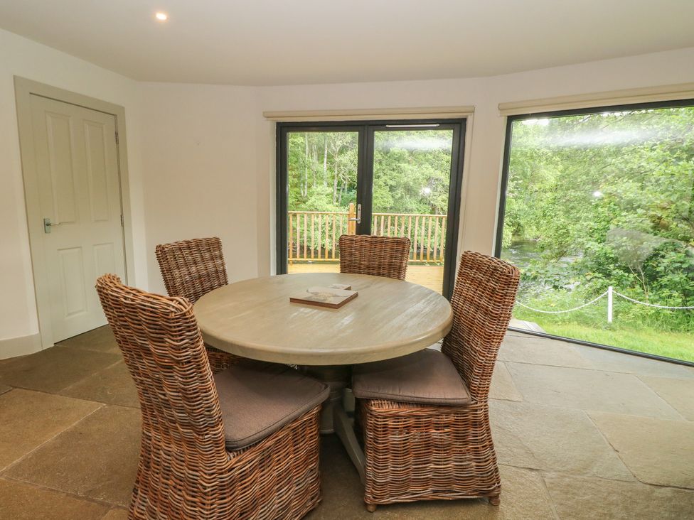 A dining room with a round table and chairs at Otter’s Holt in Killin