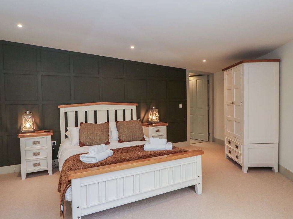 A bedroom with a bed and wardrobe at Otter’s Holt in Killin