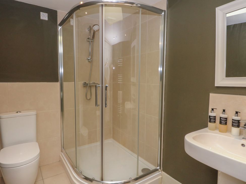 A bathroom with a shower, toilet, and sink at Otter’s Holt in Killin