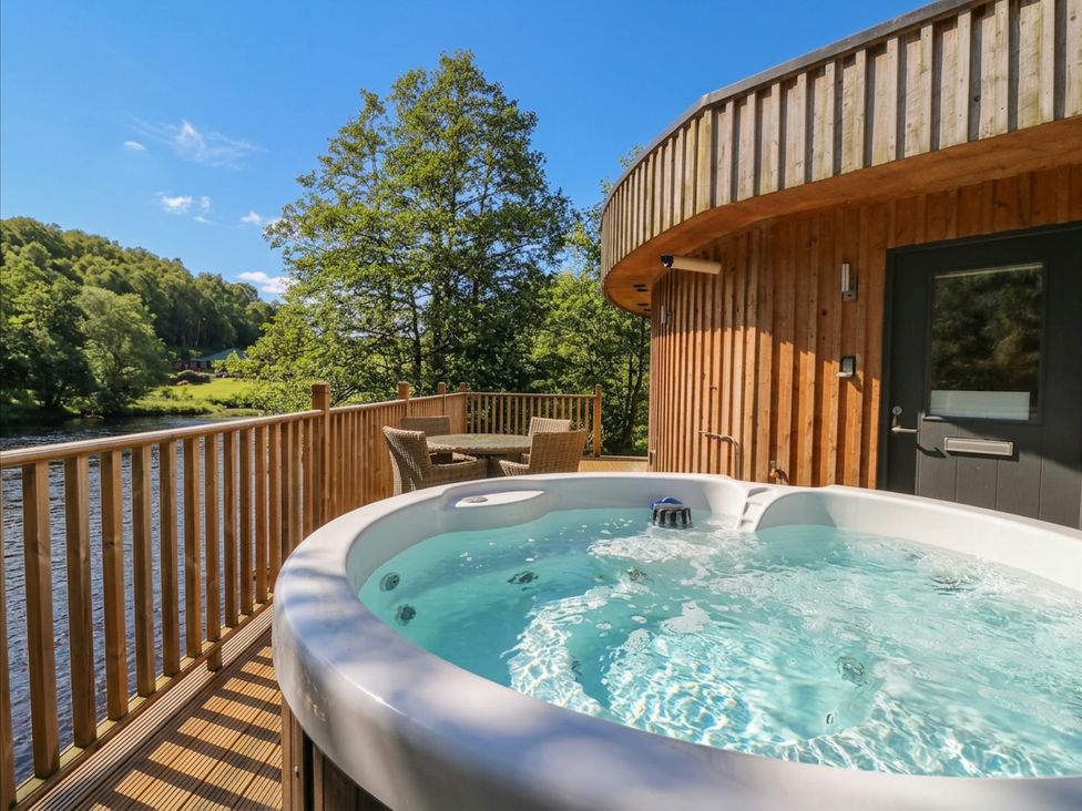 An outdoor area with a hot tub and seating at Otter’s Holt in Killin
