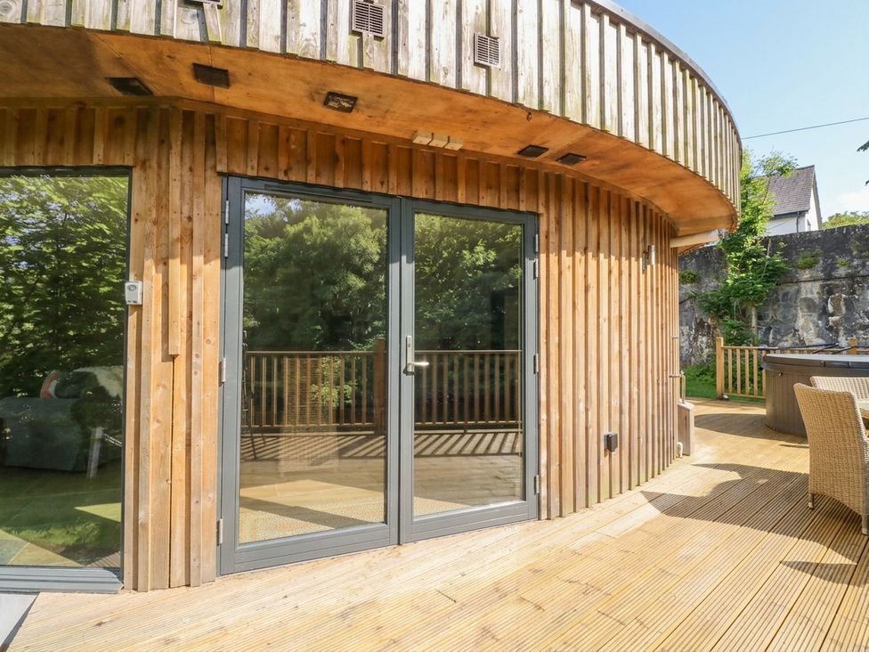 An outdoor space featuring glazed doors and wooden walls at Otter’s Holt in Killin