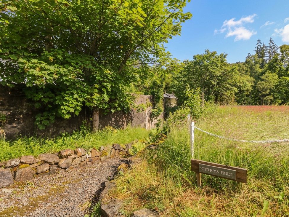 A path leading through grass and trees to Otter’s Holt in Killin