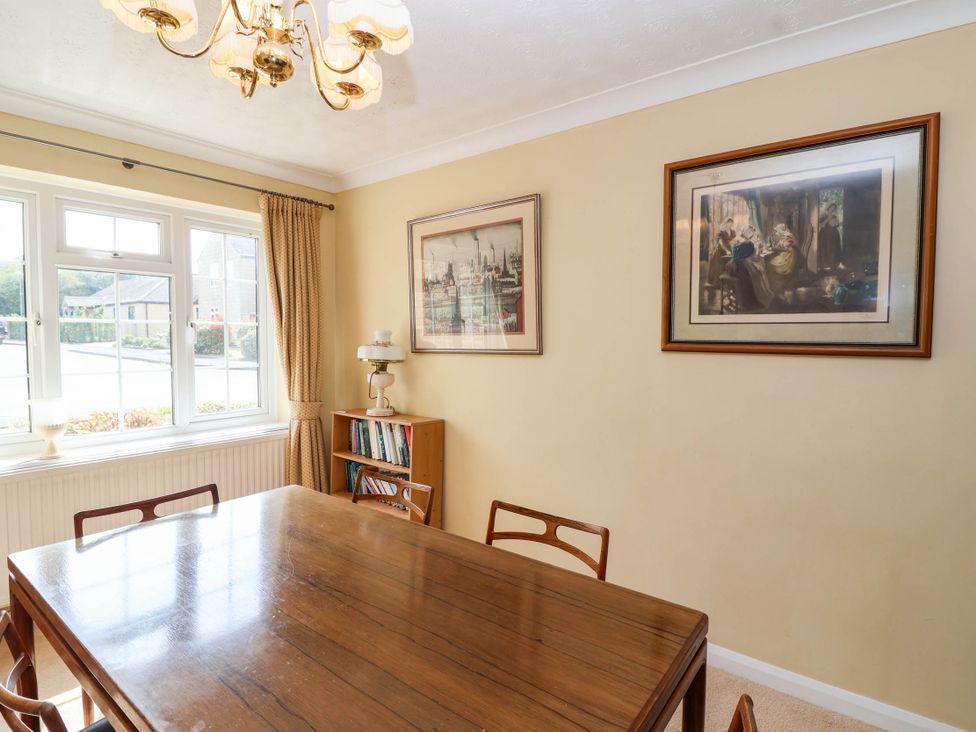 A dining room with a table, chairs, and wall art at Number 10, Broadway