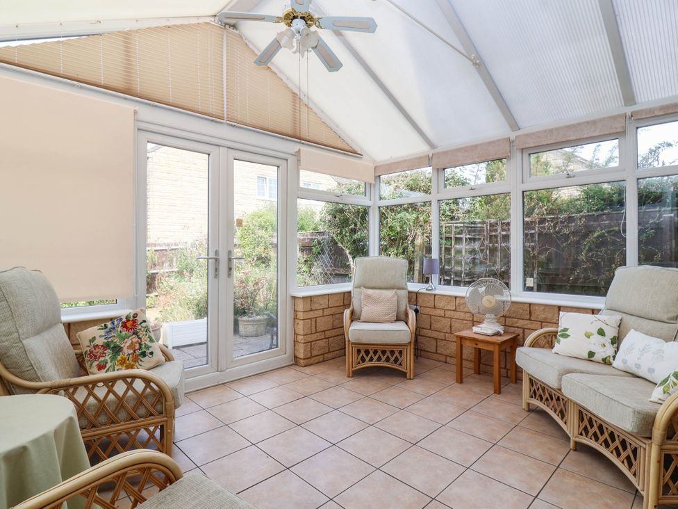 A conservatory with seating and plants at Number 10, Broadway