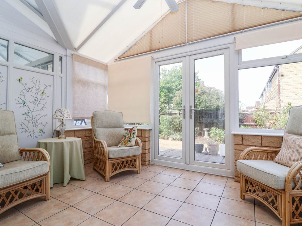 A conservatory with armchairs and a table at Number 10, Broadway