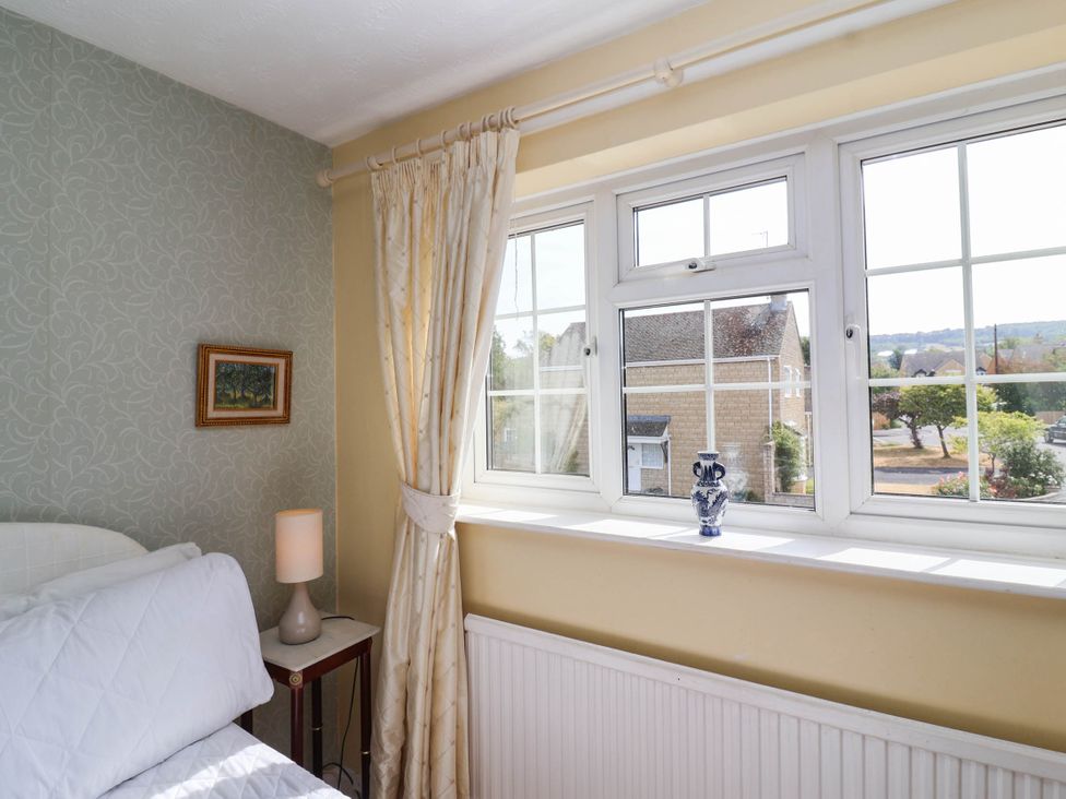 A bedroom with a bed, lamp, and window at Number 10, Broadway