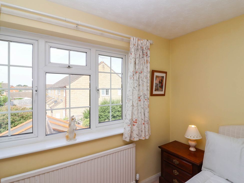 A bedroom with a window and wooden nightstand at Number 10, Broadway