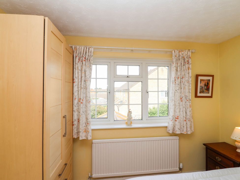A bedroom with a wardrobe, window, and nightstand at Number 10, Broadway