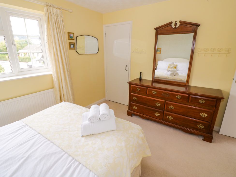 A bedroom with a bed and dresser at Number 10, Broadway in Broadway