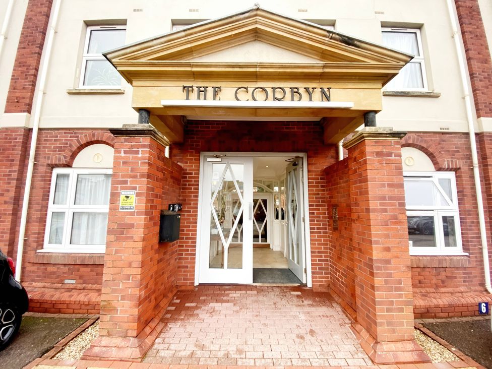 An entrance with a sign and double doors at The Corbyn in Torquay