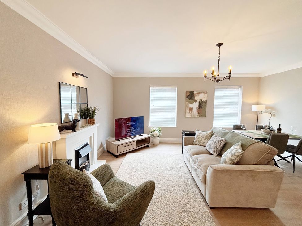 A living room with a sofa and television at The Forbes in Torquay