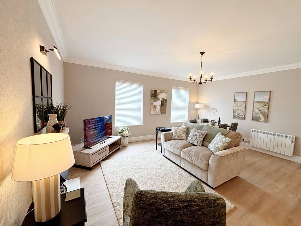 A living room with a sofa and television at The Forbes in Torquay