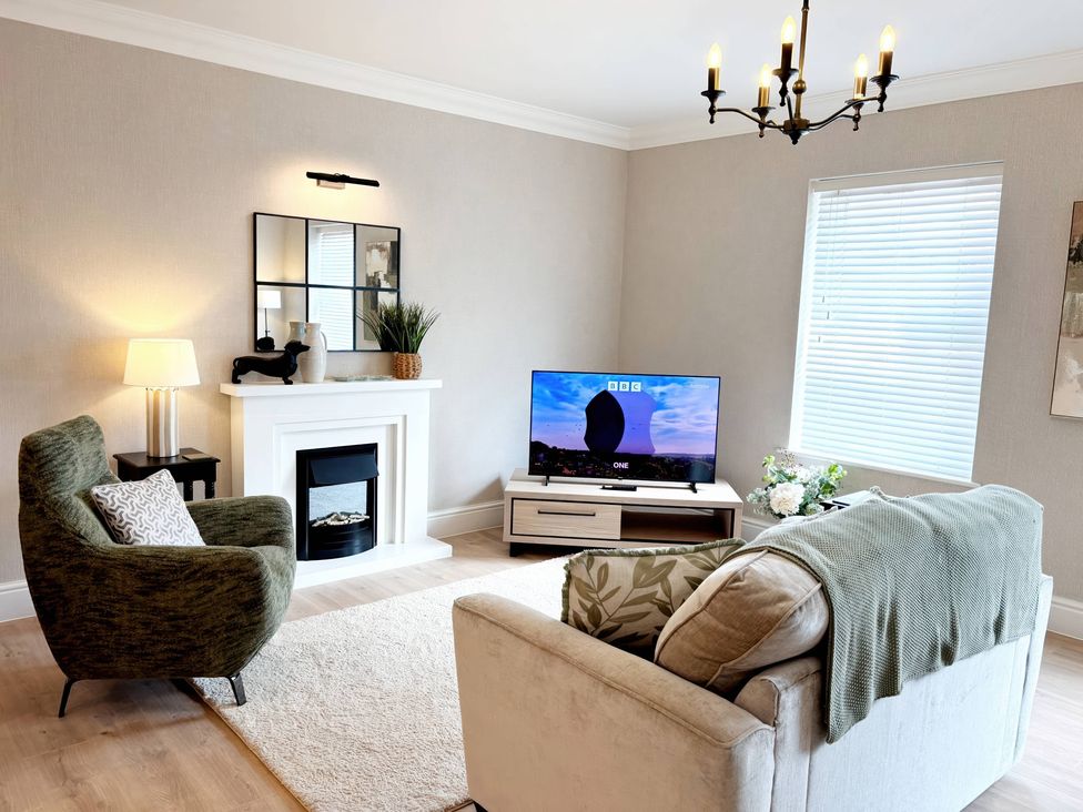 A living room with a television and seating area at The Forbes in Torquay