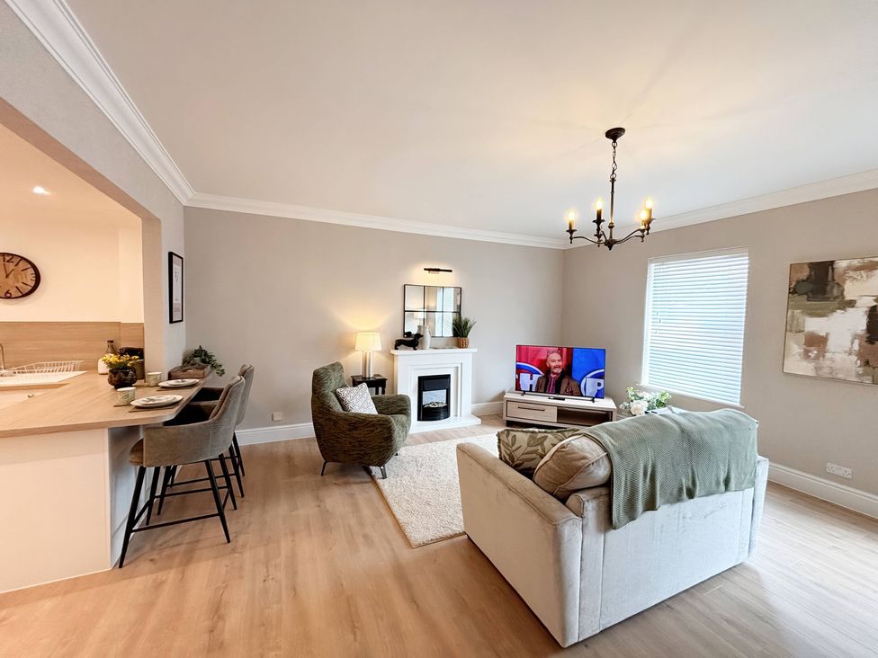 A living room with furniture and a TV at The Forbes in Torquay