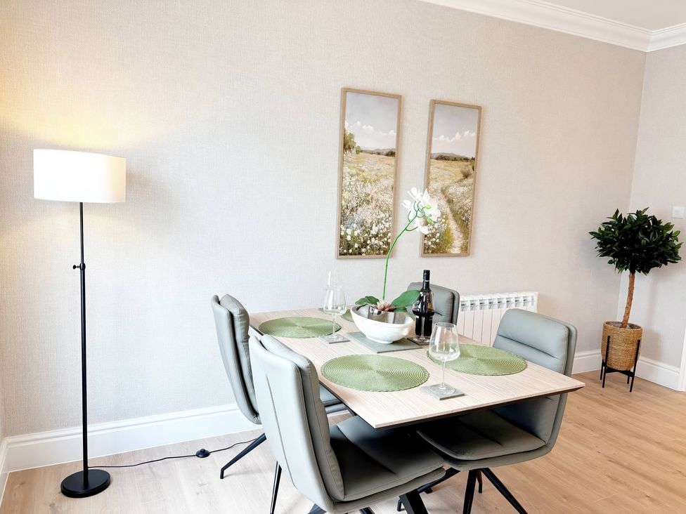 A dining table with chairs and decor at The Forbes in Torquay