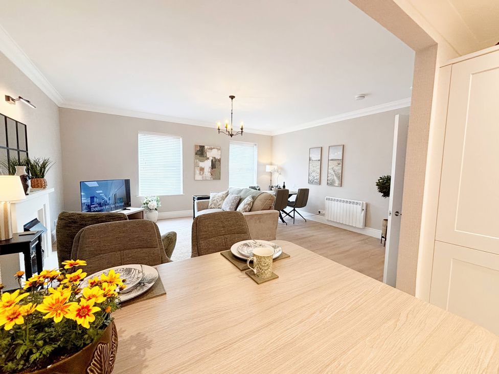 A living room with a sofa and dining table at The Forbes in Torquay