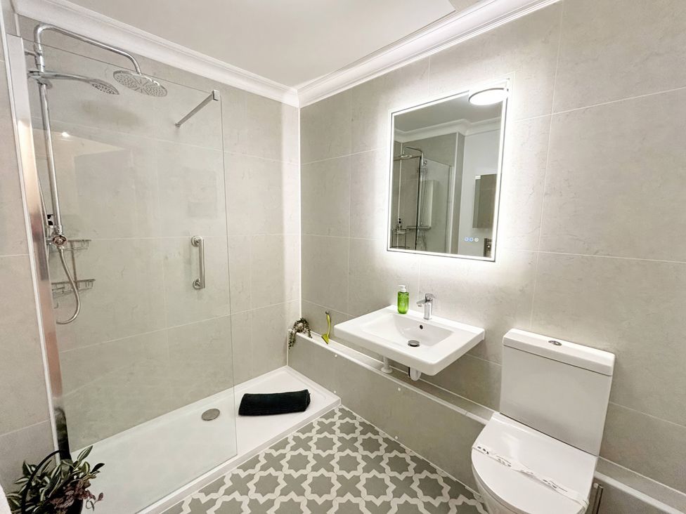 A bathroom with a shower, sink, and toilet at The Forbes in Torquay