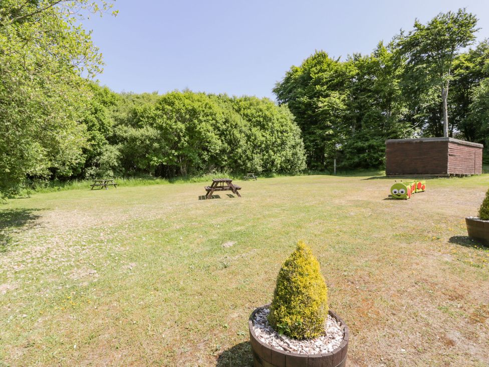 An outdoor area with picnic tables and a wooden shed at 7 Brunston Avenue