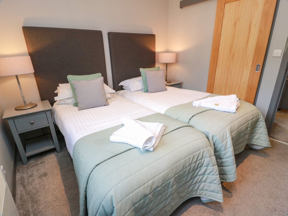 A bedroom with two single beds and a nightstand at 7 Brunston Avenue