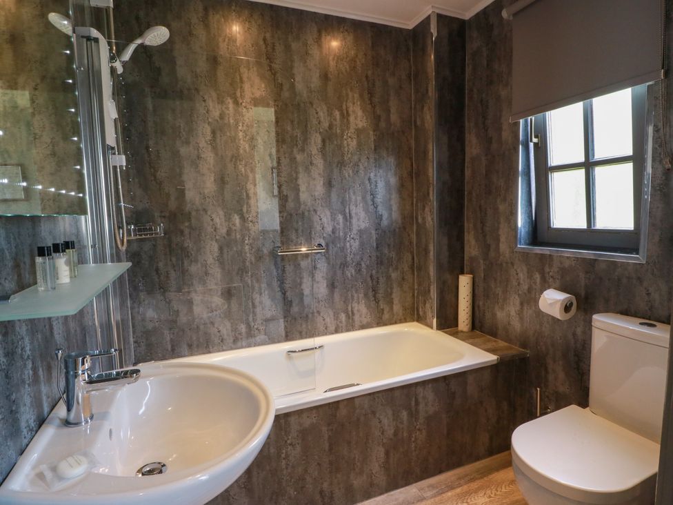 A bathroom with a bathtub, shower, and sink at 7 Brunston Avenue