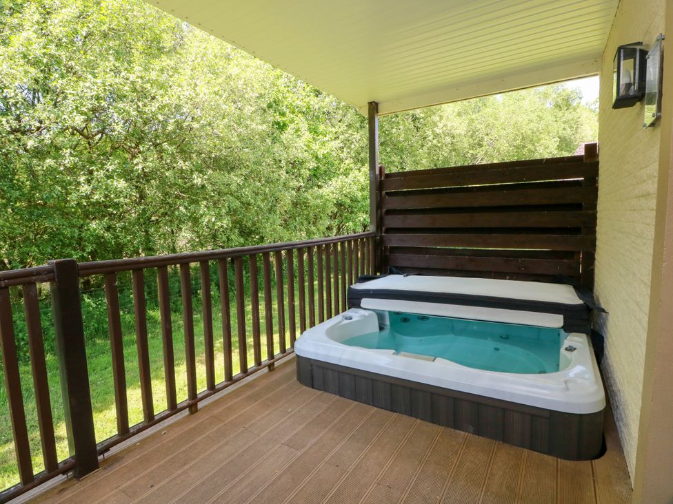 An outdoor area with a hot tub on the deck at 7 Brunston Avenue