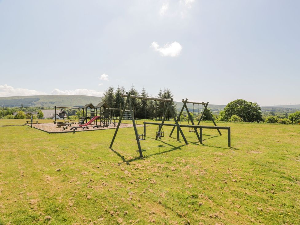 A playground with swings and a slide in an outdoor area at 7 Brunston Avenue