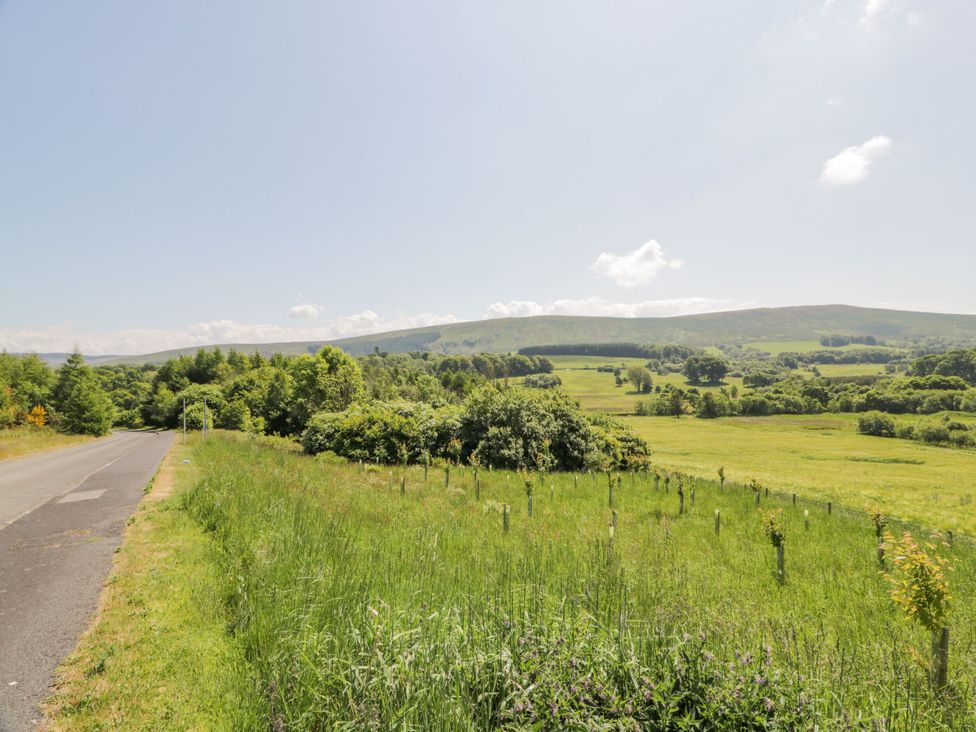 A view of a road with grass and trees alongside hills in the background at 7 Brunston Avenue