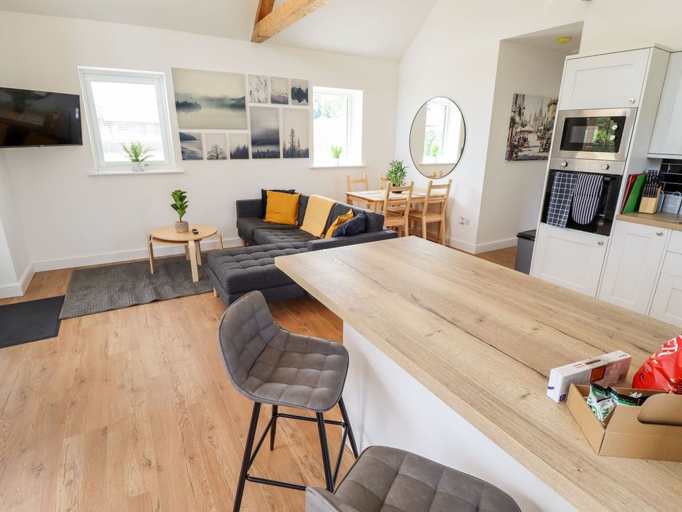 A living room with a sofa and dining table at The Lilac Owl in Lincoln