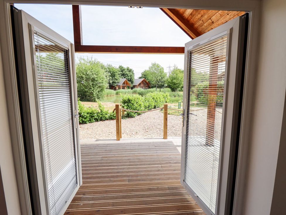 An outdoor patio with double doors leading to a view of water at The Lilac Owl in Lincoln