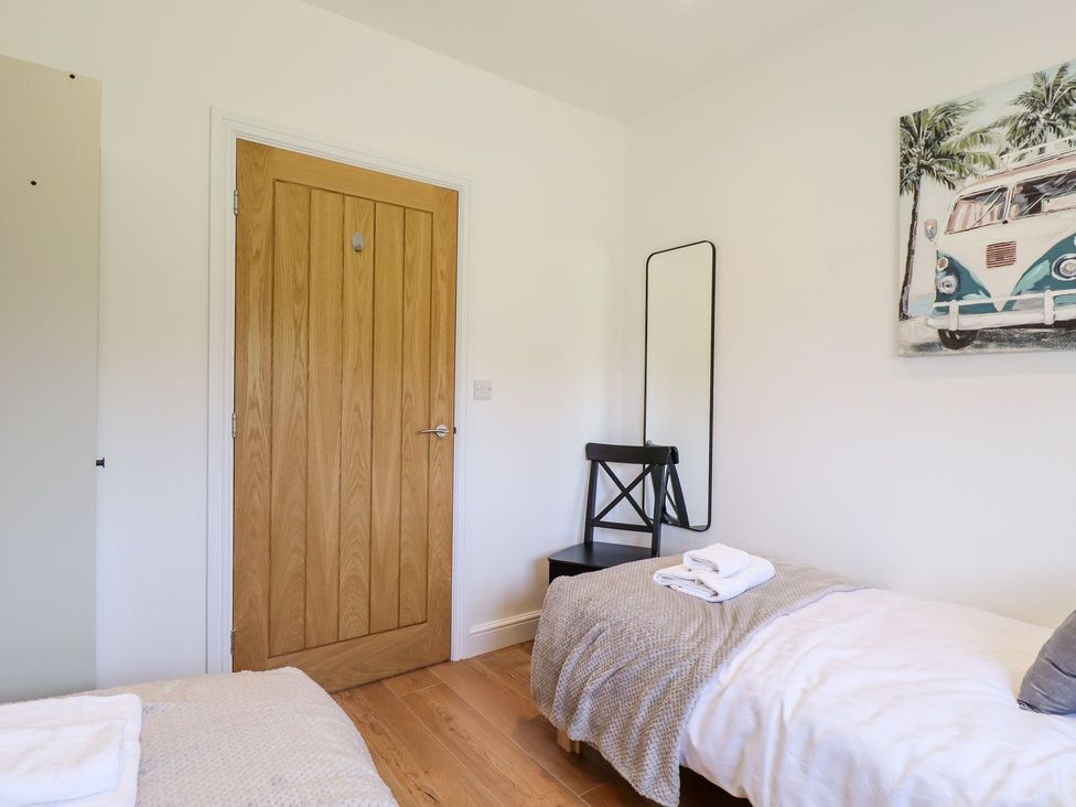 A bedroom featuring a bed, a mirror, and a chair at The Lilac Owl in Lincoln
