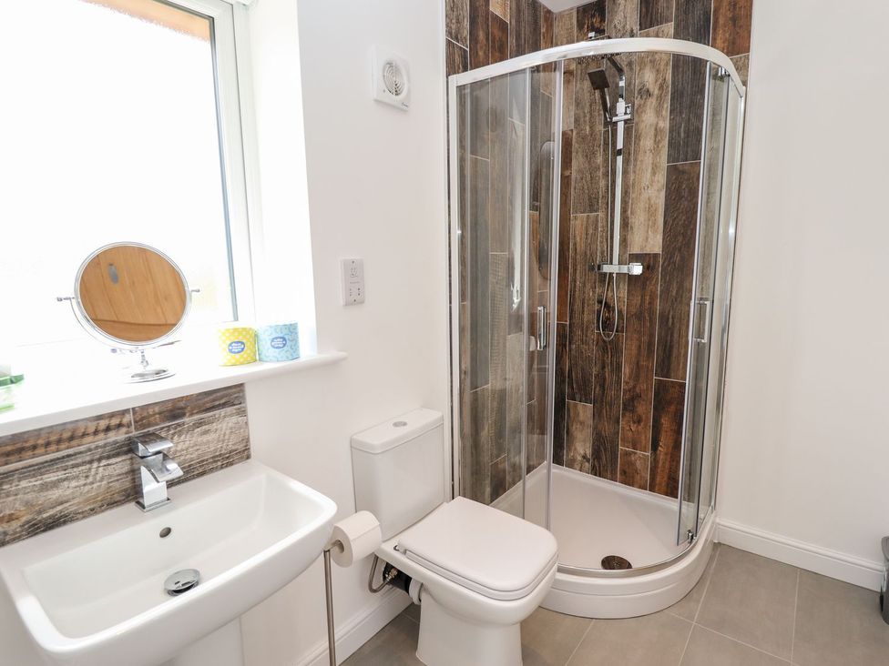 A bathroom with a shower, toilet, and sink at The Lilac Owl in Lincoln