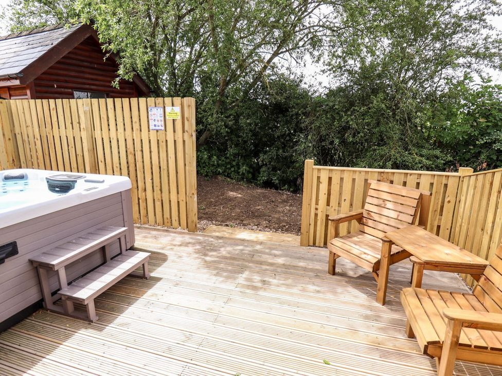 An outdoor area with a hot tub and wooden seating at The Lilac Owl in Lincoln
