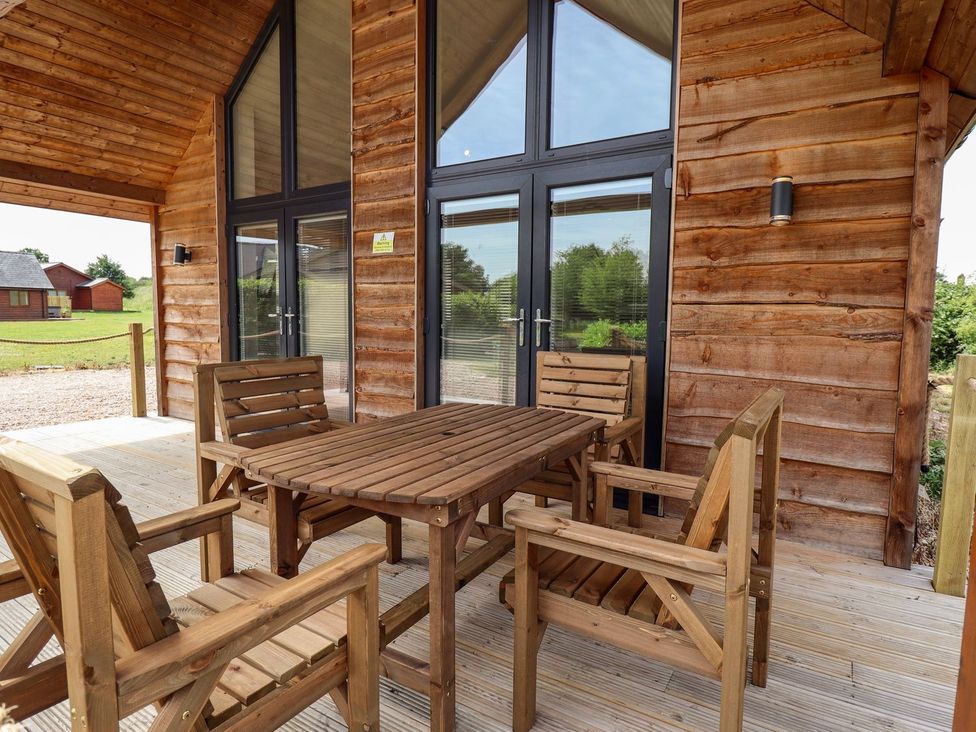 A patio with a wooden table and chairs at The Lilac Owl in Lincoln