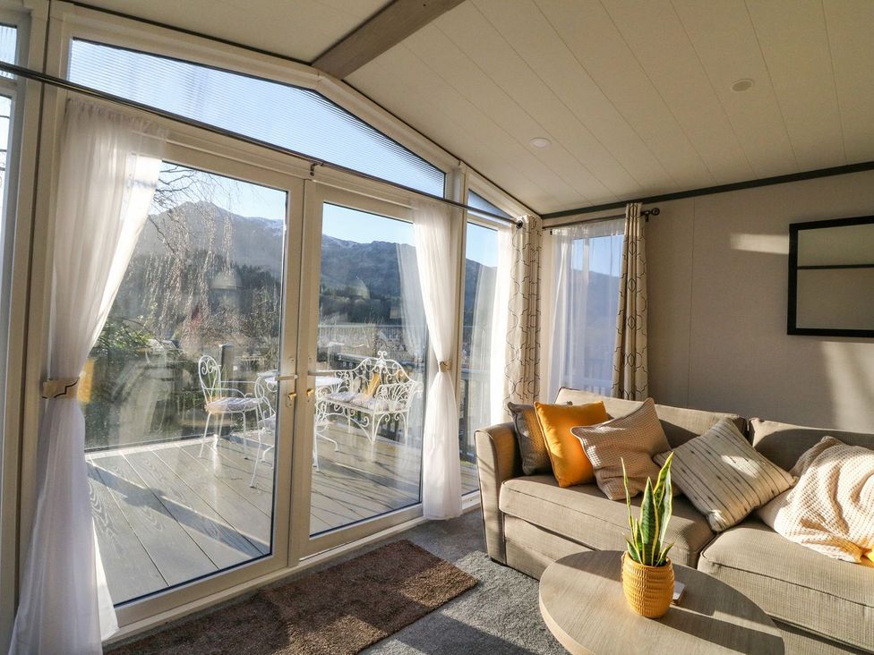 A sunroom with a sofa and sliding doors at Hollybirch in Crieff