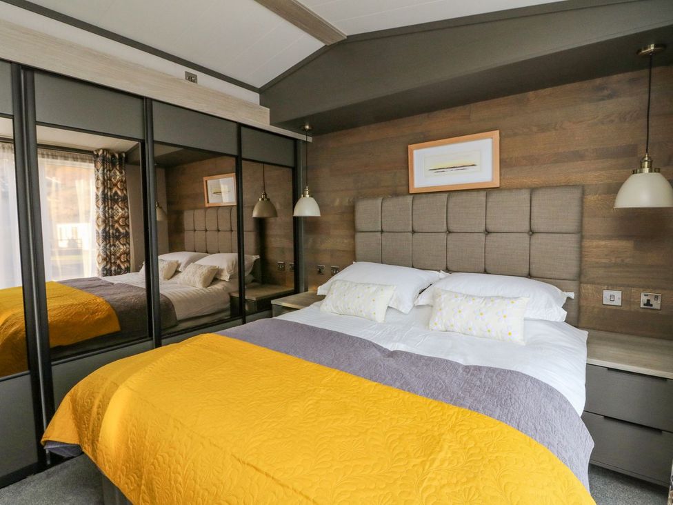 A bedroom with a mirrored wardrobe and a bed at Hollybirch in Crieff
