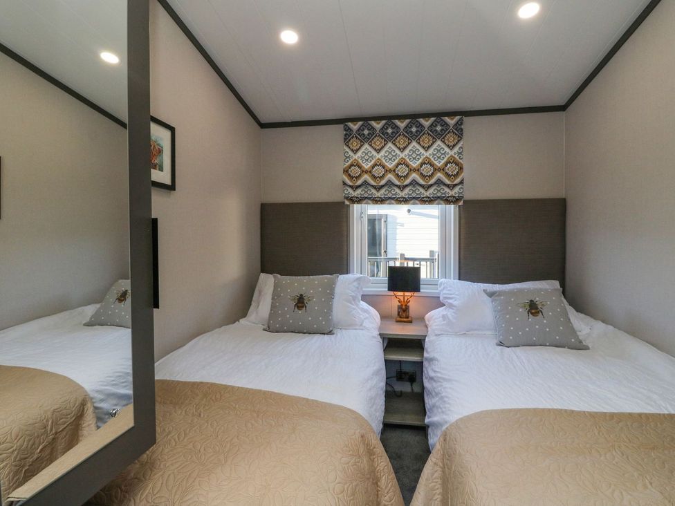 A bedroom with two beds and a lamp in Hollybirch, Crieff