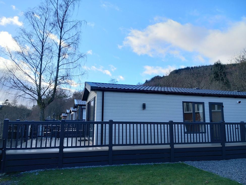 A house with a deck and tree at Rowan in Crieff