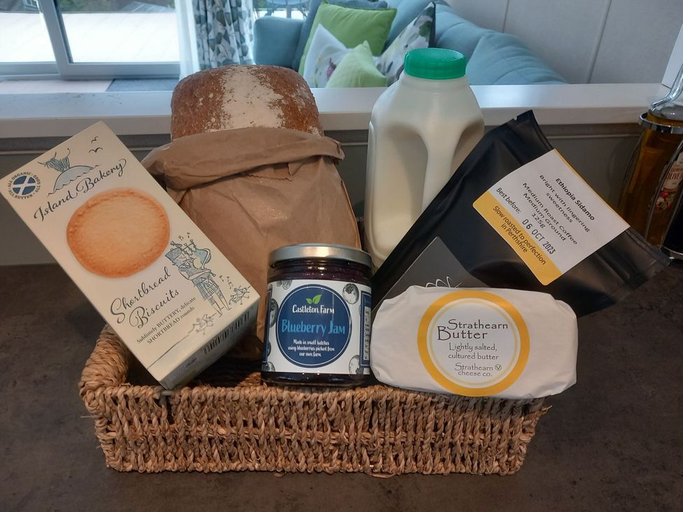 A basket with shortbread biscuits, bread, milk, blueberry jam, and butter at Rowan in Crieff