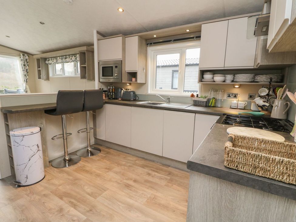 A kitchen with appliances and furniture at Rowan in Crieff