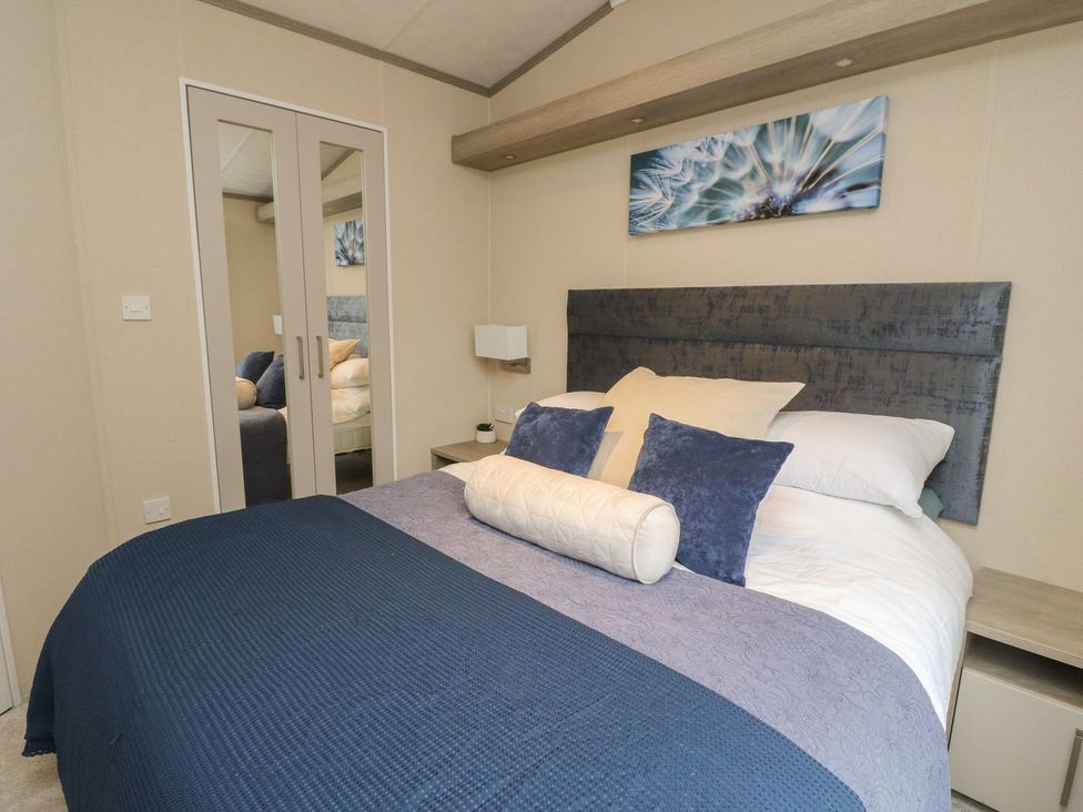 A bedroom with a bed and mirrored wardrobe at Rowan in Crieff