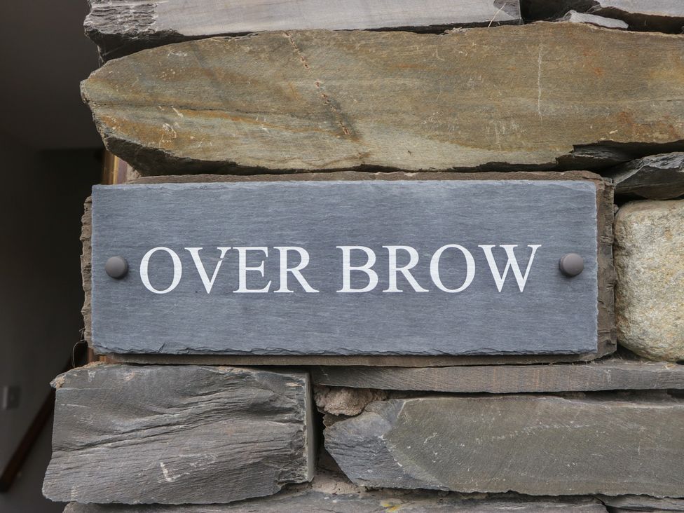 A sign reading 'OVER BROW' mounted on stone at Over Brow Cottage in Coniston