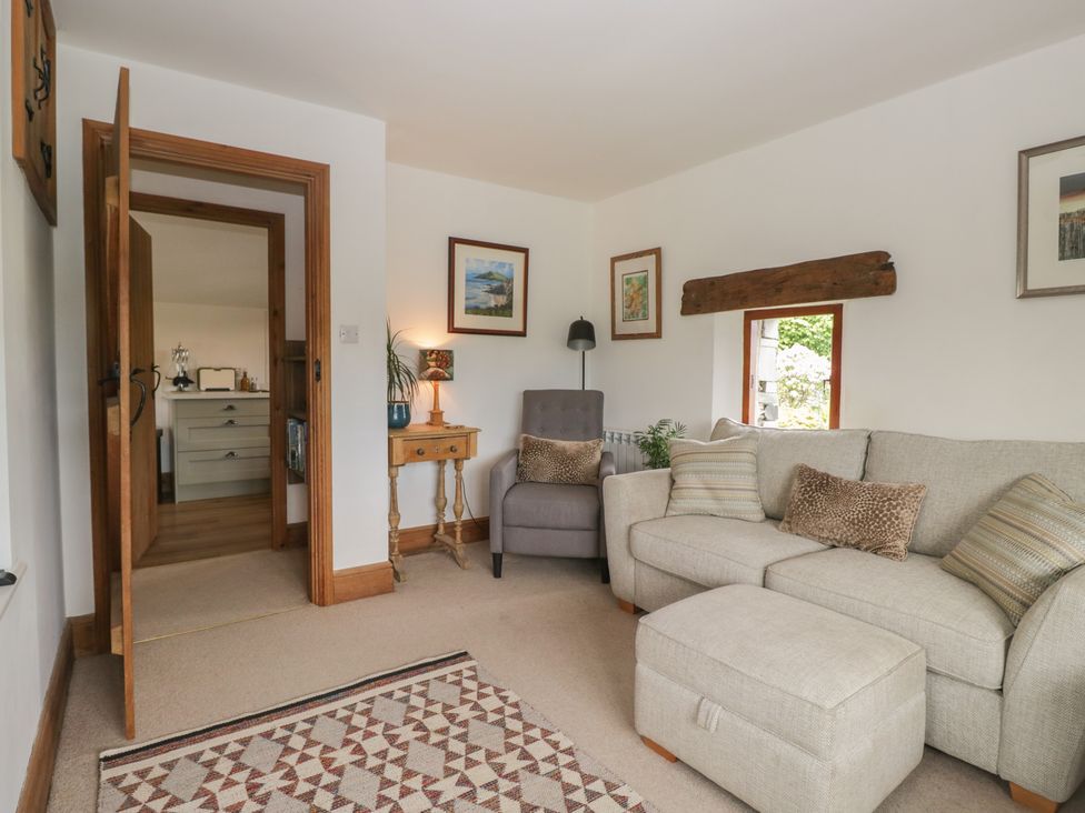 A living room with a sofa and armchair at Over Brow Cottage in Coniston