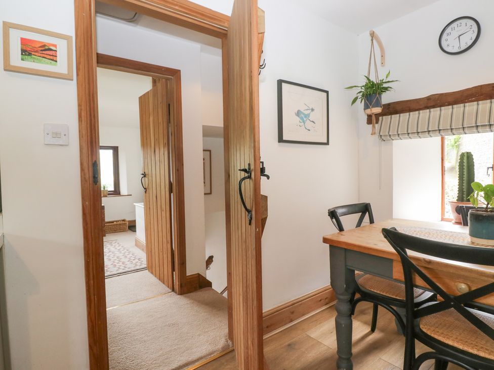 A dining room with a table and chairs at Over Brow Cottage in Coniston