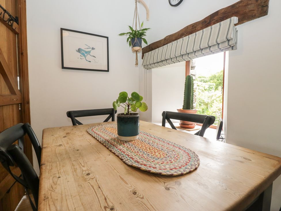 A dining room with a table and chairs at Over Brow Cottage in Coniston