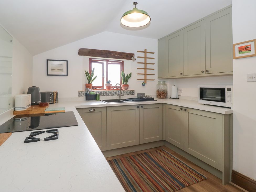 A kitchen with cabinets and appliances at Over Brow Cottage in Coniston