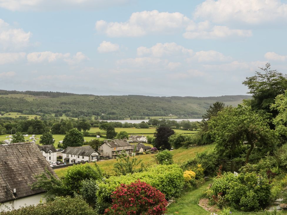A view of fields and houses with a lake at Over Brow Cottage in Coniston