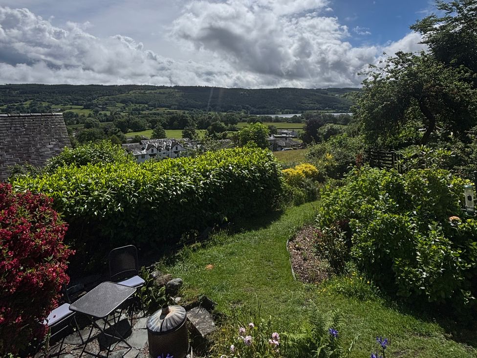 A garden with chairs and a table at Over Brow Cottage in Coniston