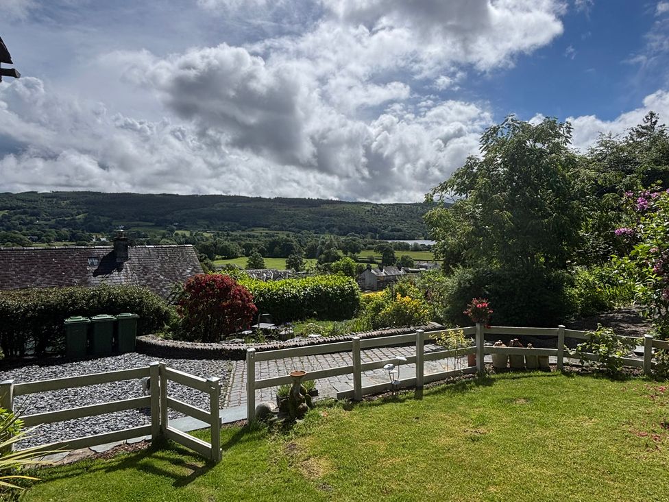 A garden with a pathway and green bins at Over Brow Cottage in Coniston
