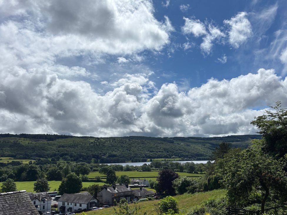 A view of houses and fields overlooking a lake at Over Brow Cottage in Coniston