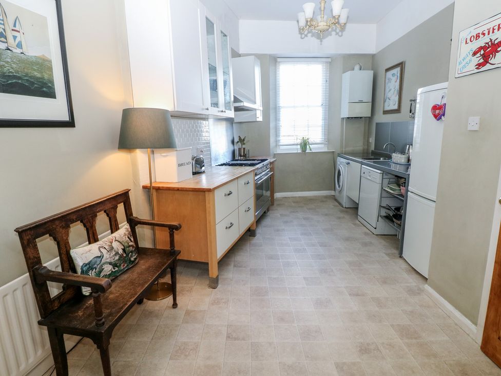 A kitchen with appliances and a bench at Sea Suite 